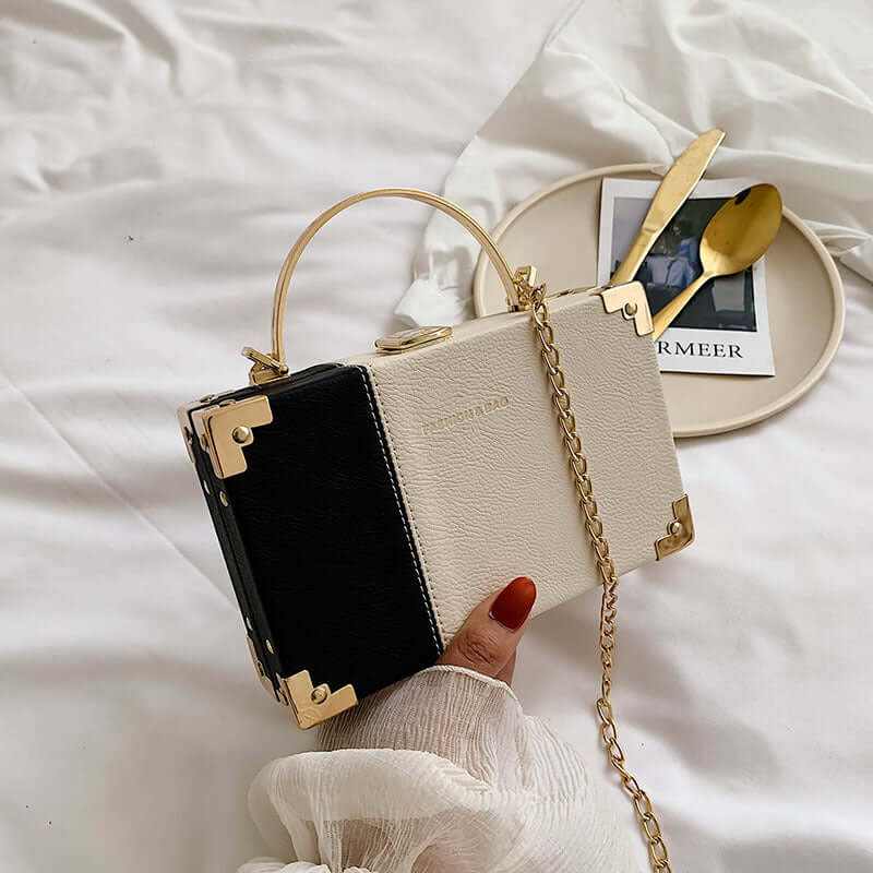 Elegant ladies handle clutch purse in black and white, perfect for parties, with gold accents and a stylish design.