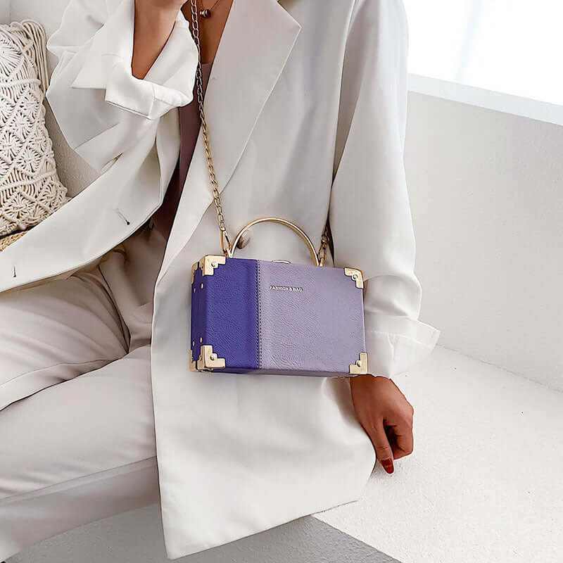 Elegant purple handle clutch purse box worn by a woman in chic outfit, perfect for stylish parties.