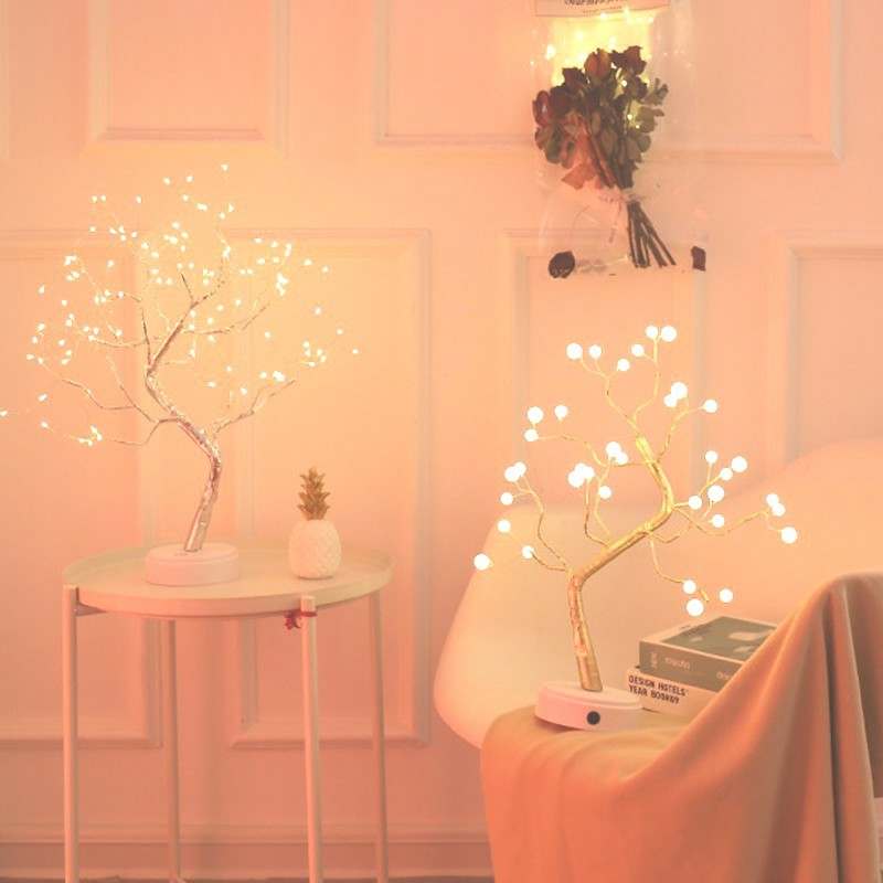 LED Christmas tree night light with warm white glowing bulbs on a tree-shaped design placed on a table and chair in a cozy room setting