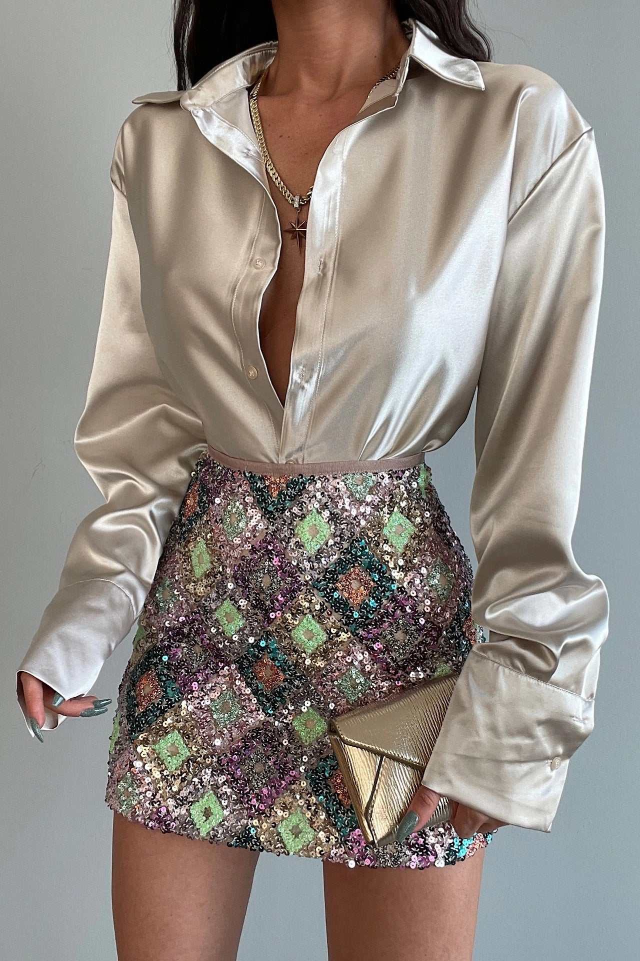 Elegant long sleeve satin lapel shirt paired with a sequined mini skirt, perfect for a chic night out.