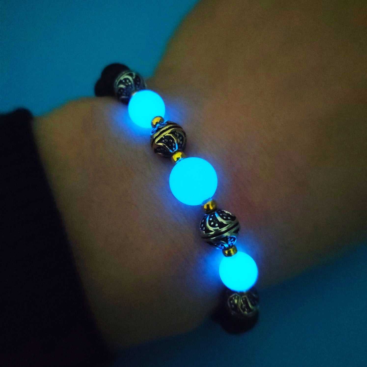 Luminous beaded bracelet for women with glowing fluorescent and volcanic stone beads on elastic rope in ancient bronze and silver colors