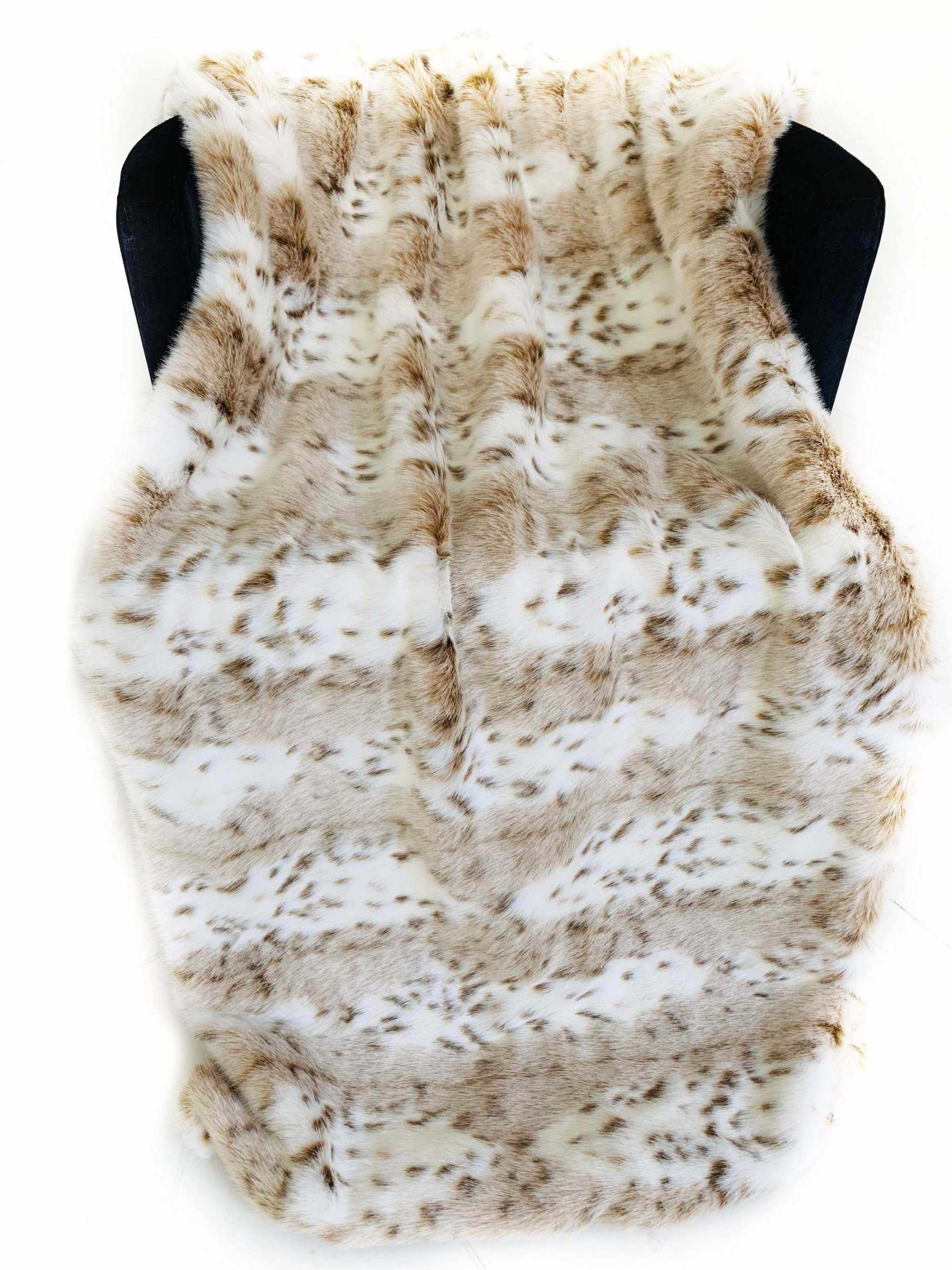 Luxury leopard faux fur throw blanket in taupe and black, soft, reversible design, ideal home decor piece.