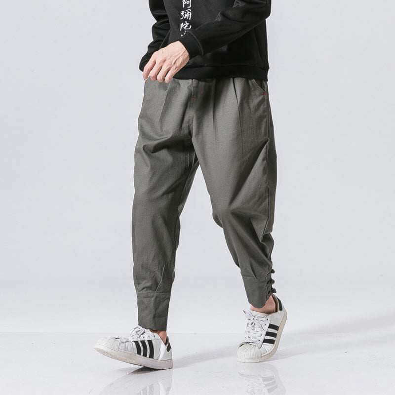 Men's buckle casual pants in gray cotton blend with tapered fit and button placket design.