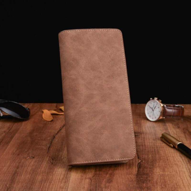 Men's compact genuine leather wallet on a wooden surface, showcasing its elegant design and quality craftsmanship.