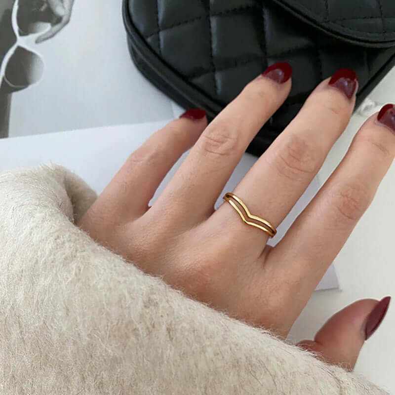 Minimalist 18K gold plated dainty chevron stacking ring on hand with burgundy nails