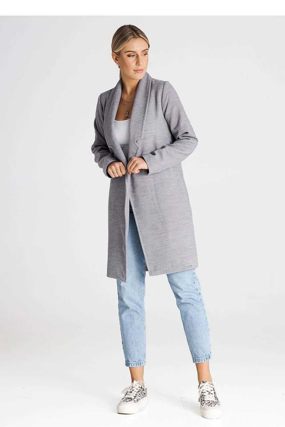 Model wearing a minimalist gray coat with a lined collar, styled with casual jeans and sneakers.