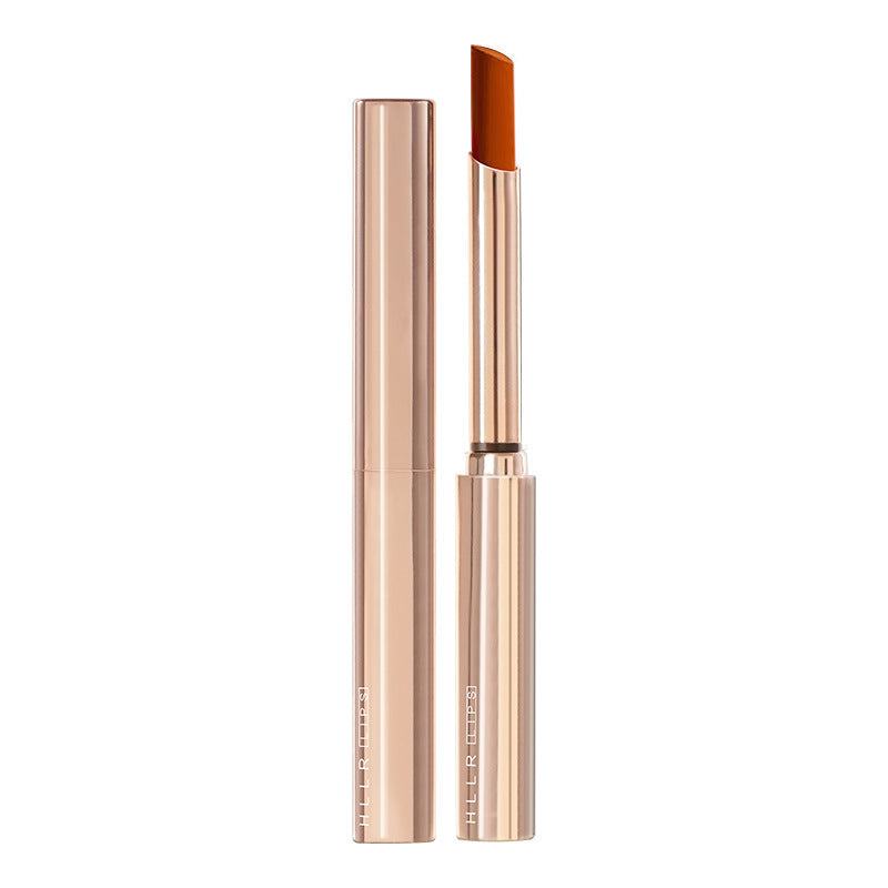 Moisturizing cosmetics small tube lipstick in warm brown shade with sleek golden packaging