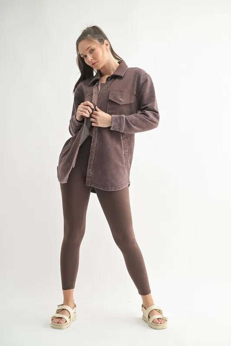Woman wearing a MONO B snap-on shacket with pockets, styled with leggings and sandals, showcasing a trendy look.