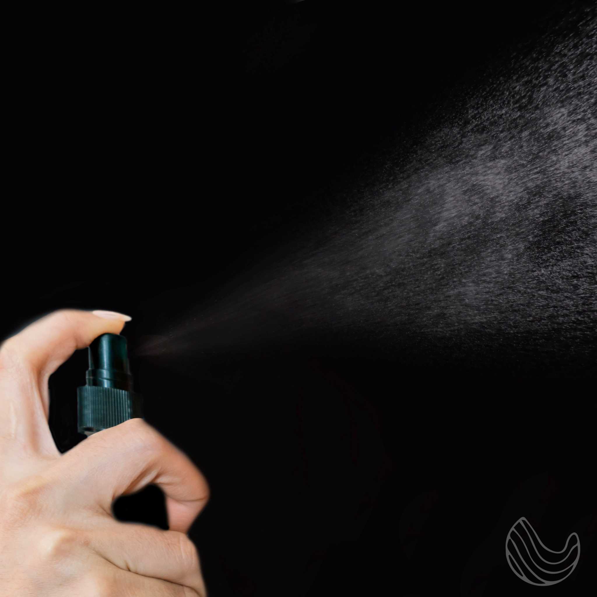 Hand spraying Natural Grapefruit Pillow Linen Spray, releasing a mist for relaxation and aromatherapy.