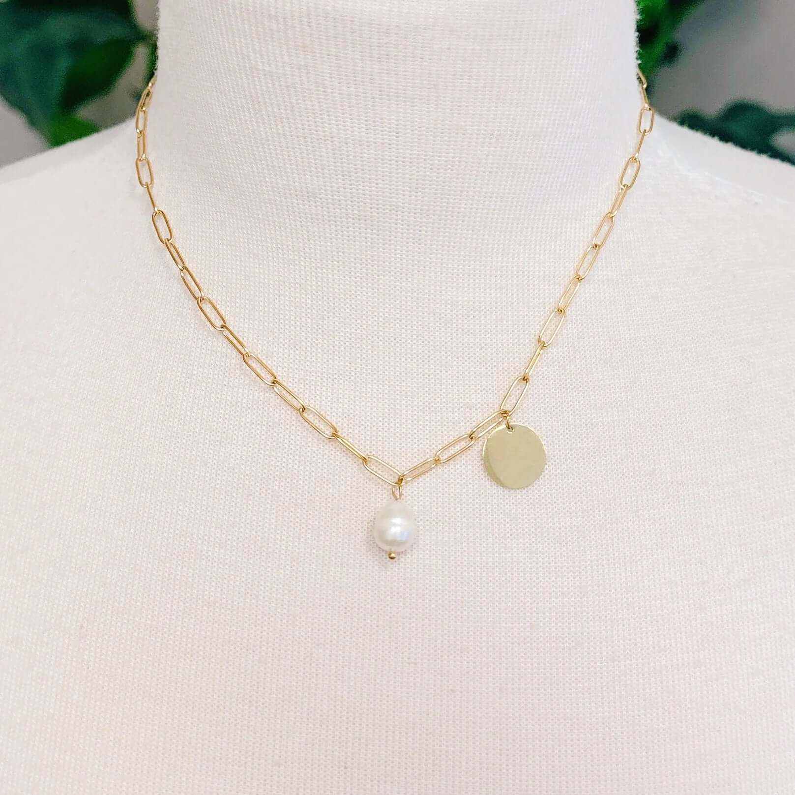 Freshwater pearl and gold disc chain necklace on a display, featuring contemporary elegance and chic design.