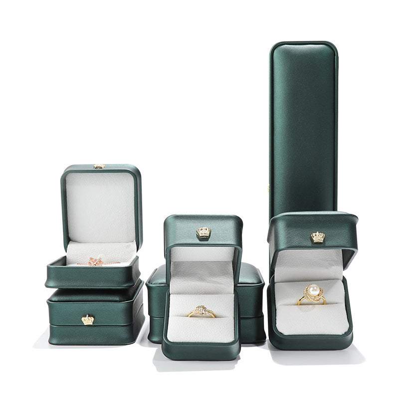 Elegant green jewelry display case showcasing rings and pendants for proposals and gifts.