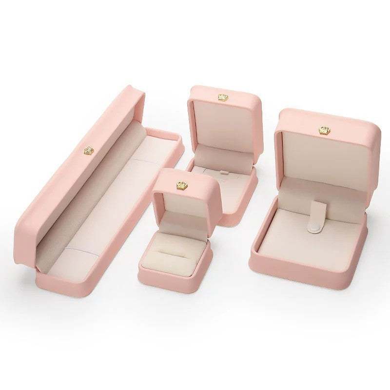 Stylish pink pendant and bracelet display cases, perfect for keeping jewelry organized and presenting gifts.