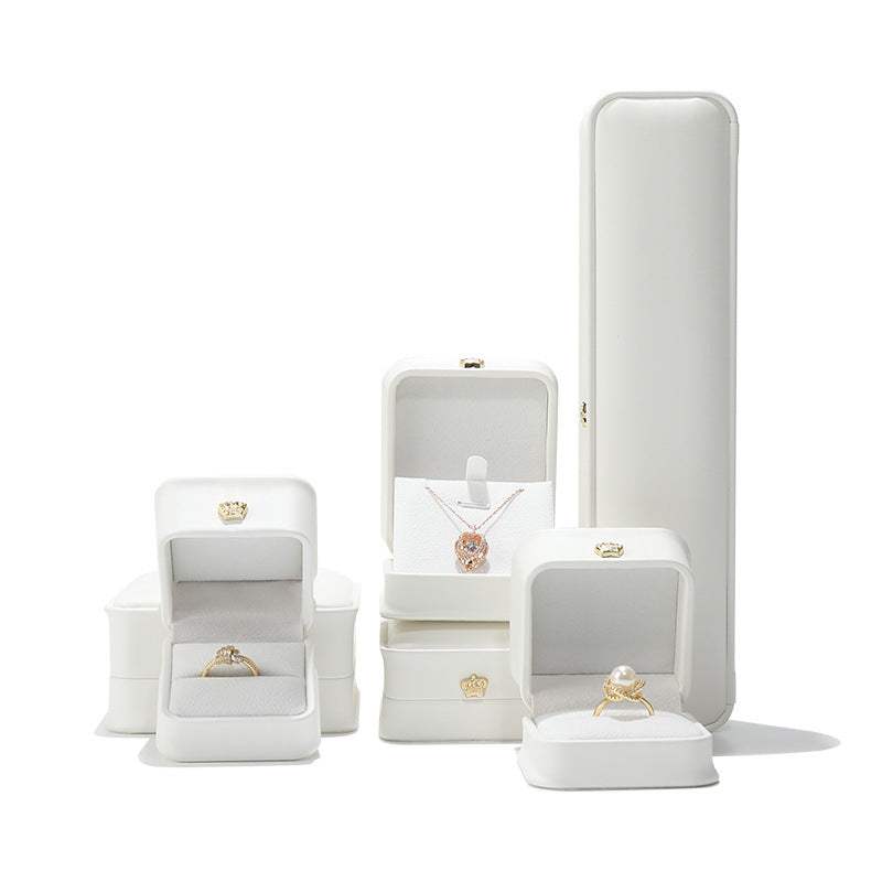 Elegant Pendant & Lace Bracelet Display Case in white, featuring various jewelry boxes for rings and necklaces.