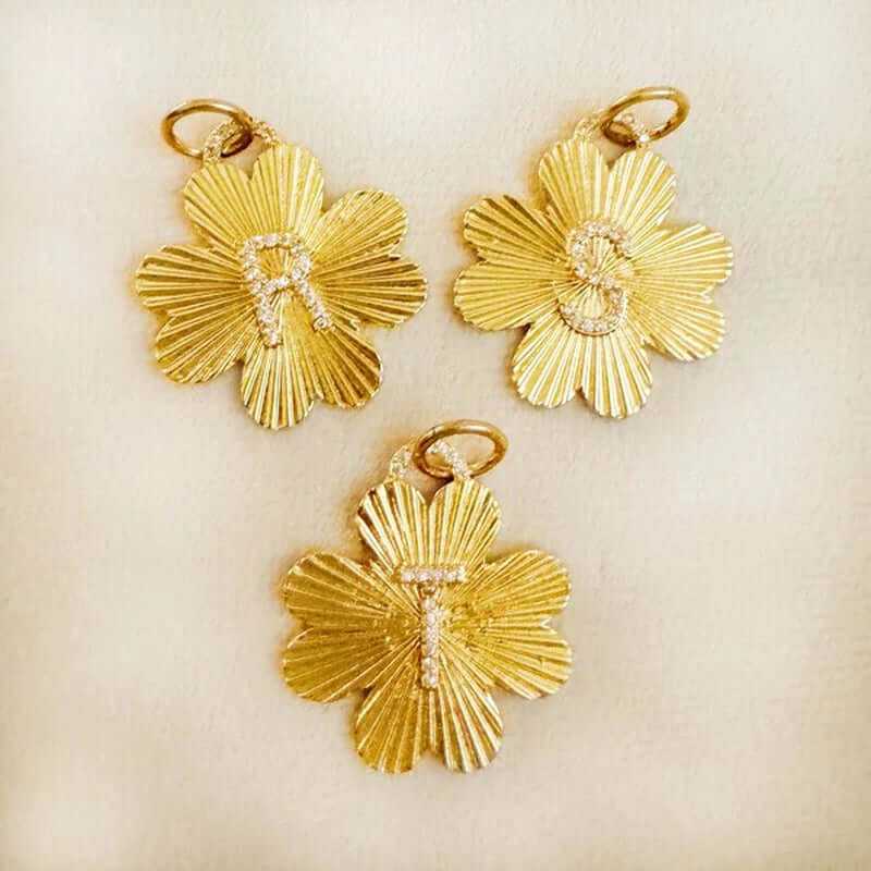 Personalized gold clover initial charms featuring letters R, S, and T on a soft background for versatile accessorizing.