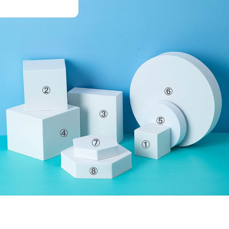 White photo prop geometric cube and cylinder decor set on blue background