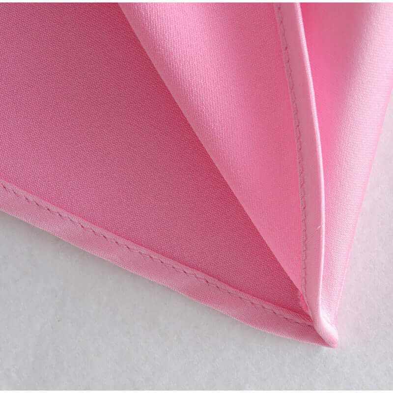 Close-up of soft pink fabric showing fine stitching and lightweight texture, perfect for elegant summer dresses.