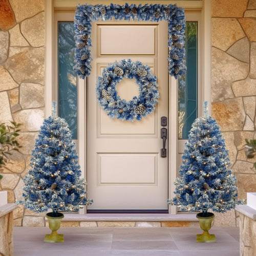 Blue pre-lit artificial Christmas tree set with garland, wreath, and entrance trees decorated with pinecones and LED lights.