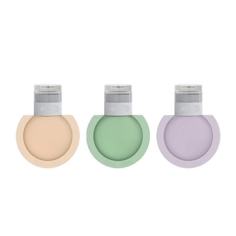 Set of three refillable travel bottles in beige, green, and lavender silicone for shampoo and lotion.