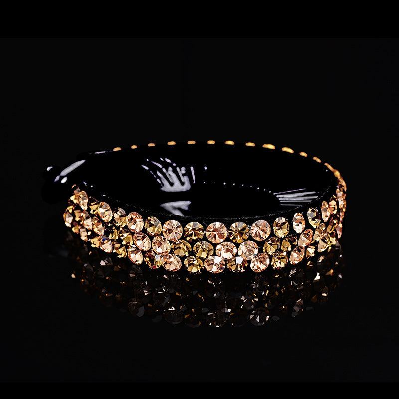 black rhinestones hair claw with gold-colored crystals on black background