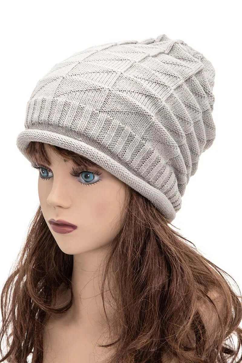 Ribbed slouchy unisex raised knit beanie in light gray worn by a mannequin with long brown hair.