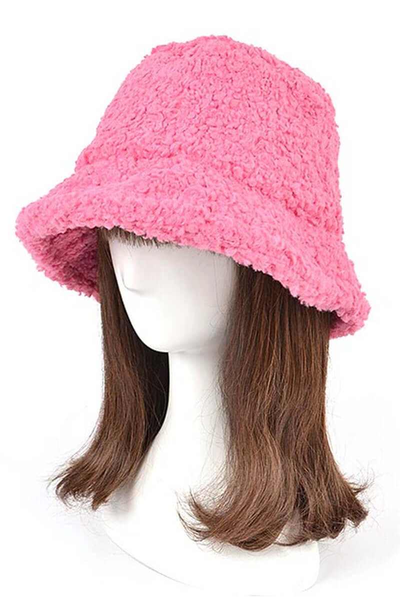 Pink shearling faux fur bucket hat modeled on a mannequin, perfect for winter warmth and style.