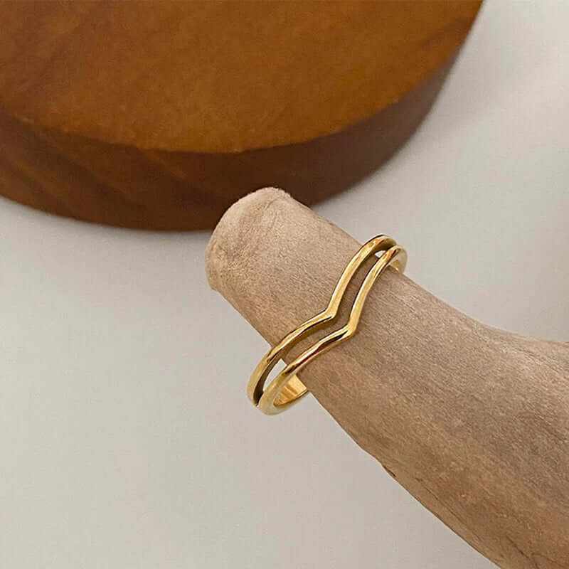 Minimalist 18K gold plated dainty chevron stacking ring on beige display stand