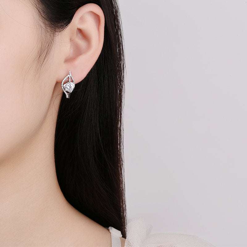 Close-up of a woman wearing silver plated simple and stylish heart-shaped earrings