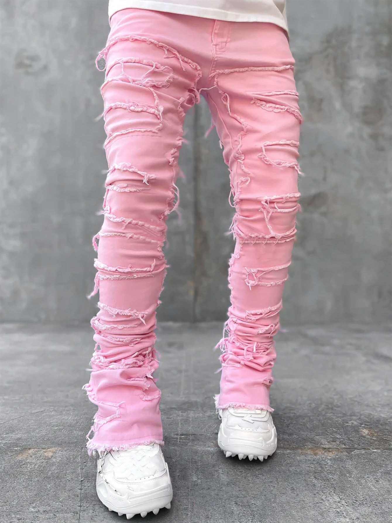 men's pink stacked jeans with distressed rips and white sneakers on concrete floor