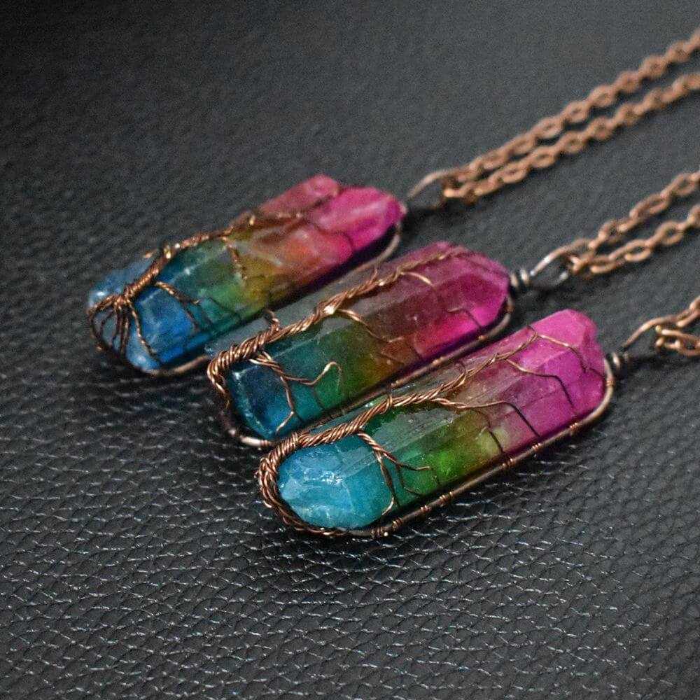 Three colorful crystal pillar necklaces in wire wrap design, showcasing vibrant shades of blue, green, and pink.