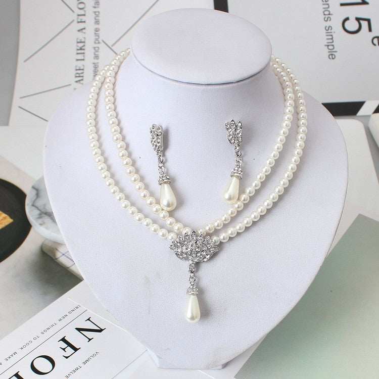 European wedding jewelry set with double pearl necklace and drop-shaped pendants on display bust