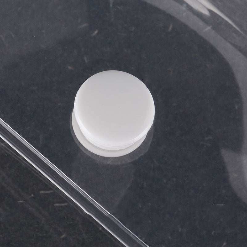 Close-up of transparent waterproof cosmetics travel kit with white round cap on black background