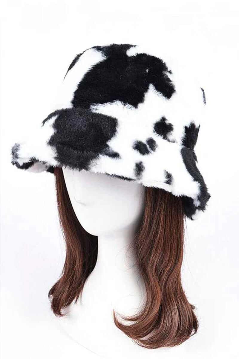 Trendy soft cow print faux fur bucket hat on a mannequin, perfect for stylish winter outfits.