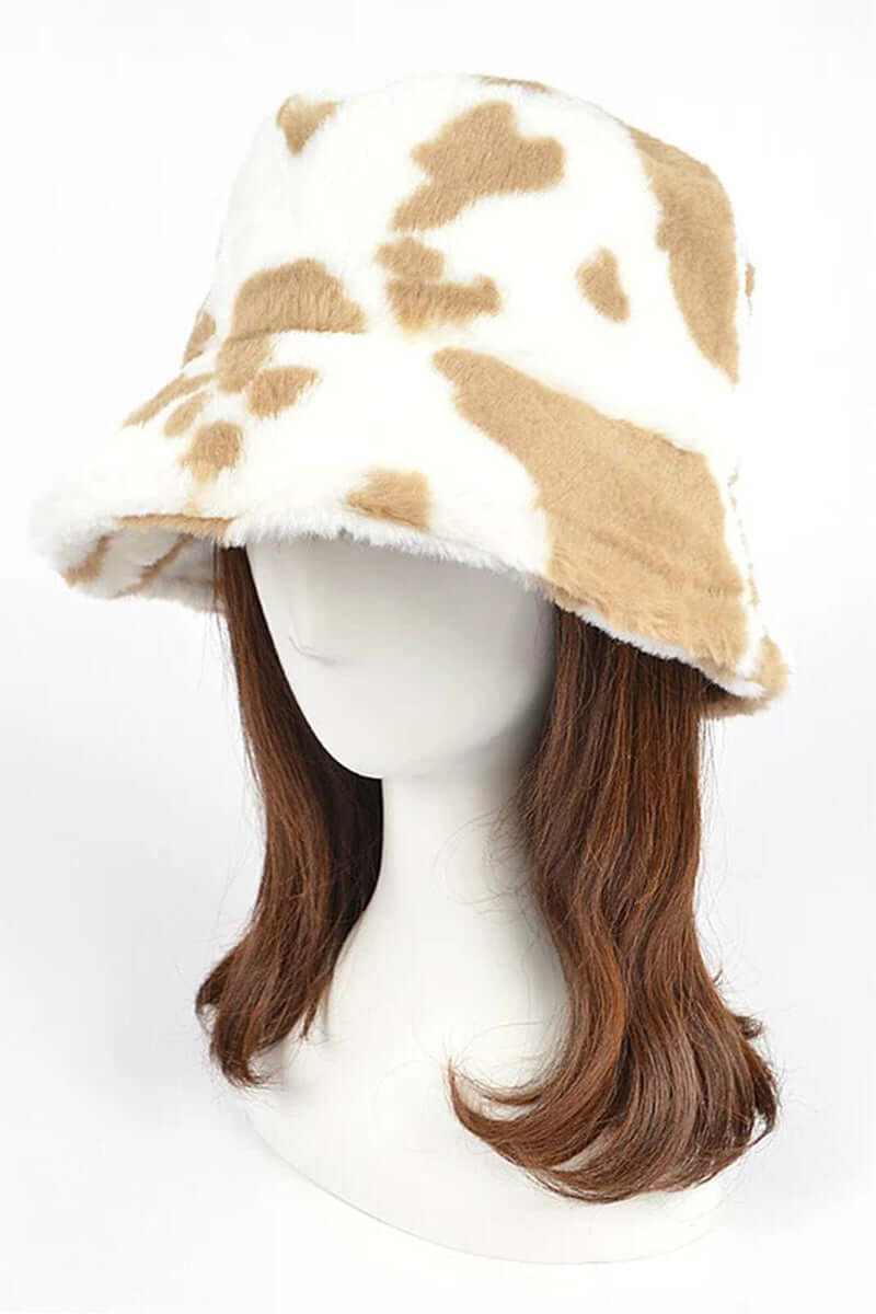 Trendy soft cow print faux fur bucket hat on a mannequin, perfect for winter fashion and street style.