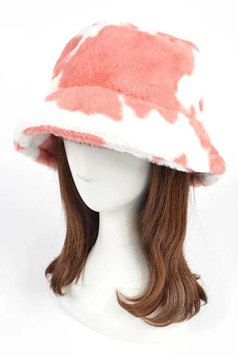 Trendy soft cow print faux fur bucket hat on a mannequin, perfect for stylish winter outfits.