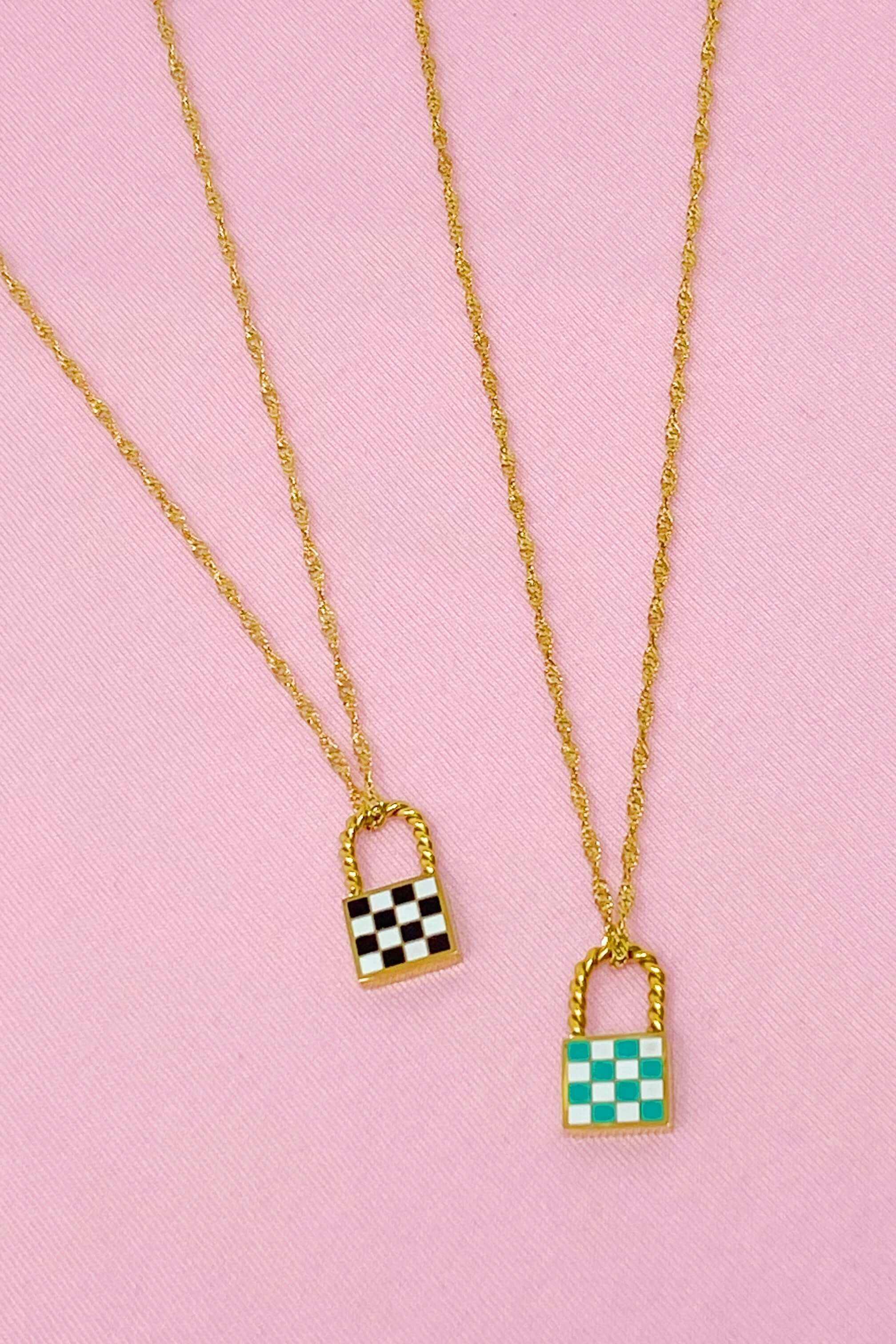 Trendy vintage checkered locket pendant necklaces with gold chains on pink background.