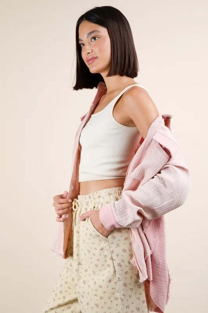 Model wearing a mineral washed oversized gauze shacket over a tank top and floral pants, showcasing a casual style.