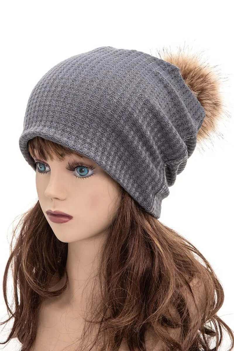 Gray knit slouchy beanie with faux fur pom pom, perfect for stylish warmth in fall and winter.