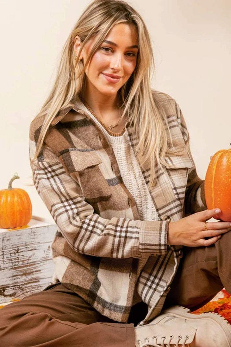 Stylish woman wearing a women flannel plaid double flap pocket jacket, surrounded by pumpkins for a cozy autumn vibe.