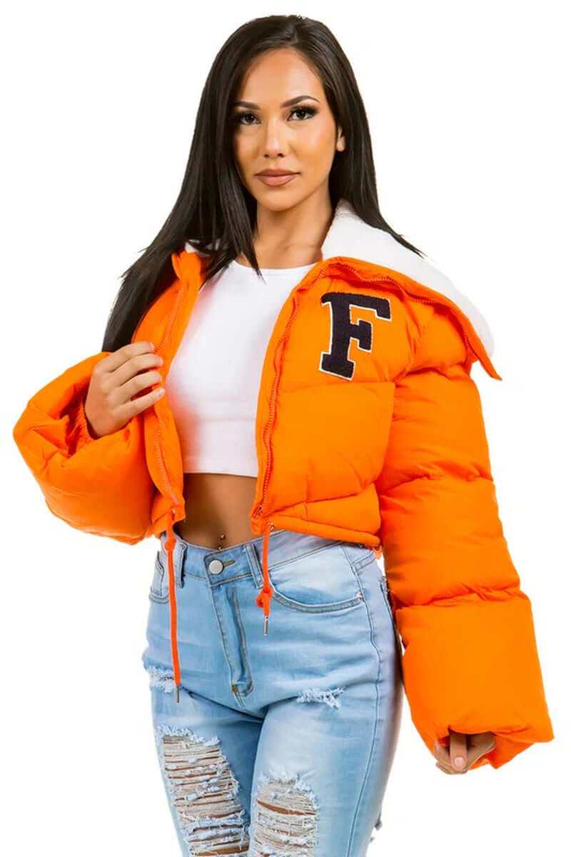 Model wearing a vibrant orange women's puffer fuzzy teddy jacket with a front zipper and oversized sleeves.