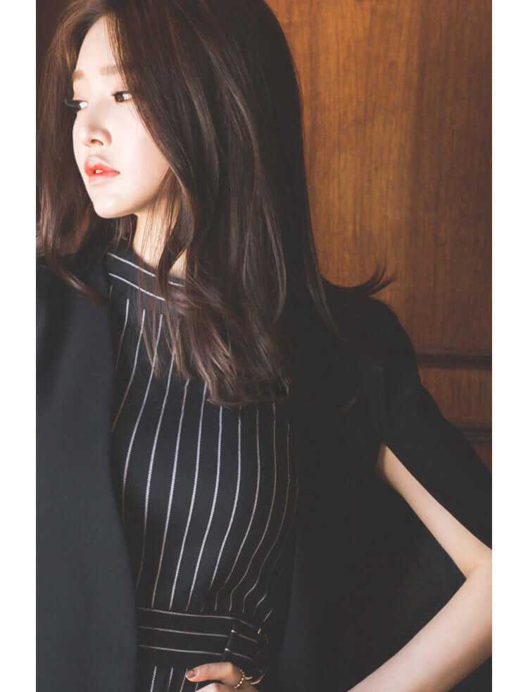 Elegant woman wearing a stylish striped dress with a blazer, showcasing a sophisticated autumn office look.