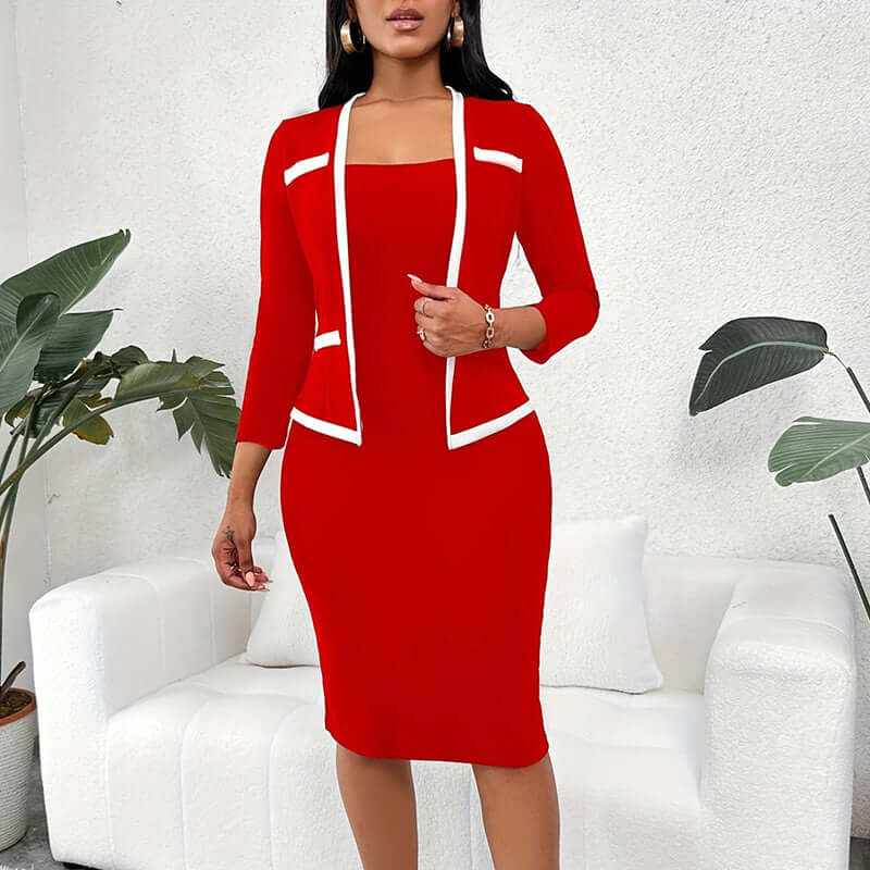 Woman wearing red mock two-piece office dress with 3/4 sleeves and white trim, standing by white couch and green plants