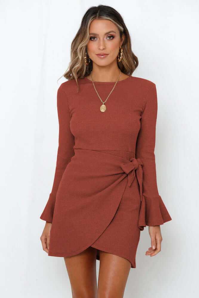 woman wearing rust brown women's ruffle long sleeve dress with flare sleeves and side tie