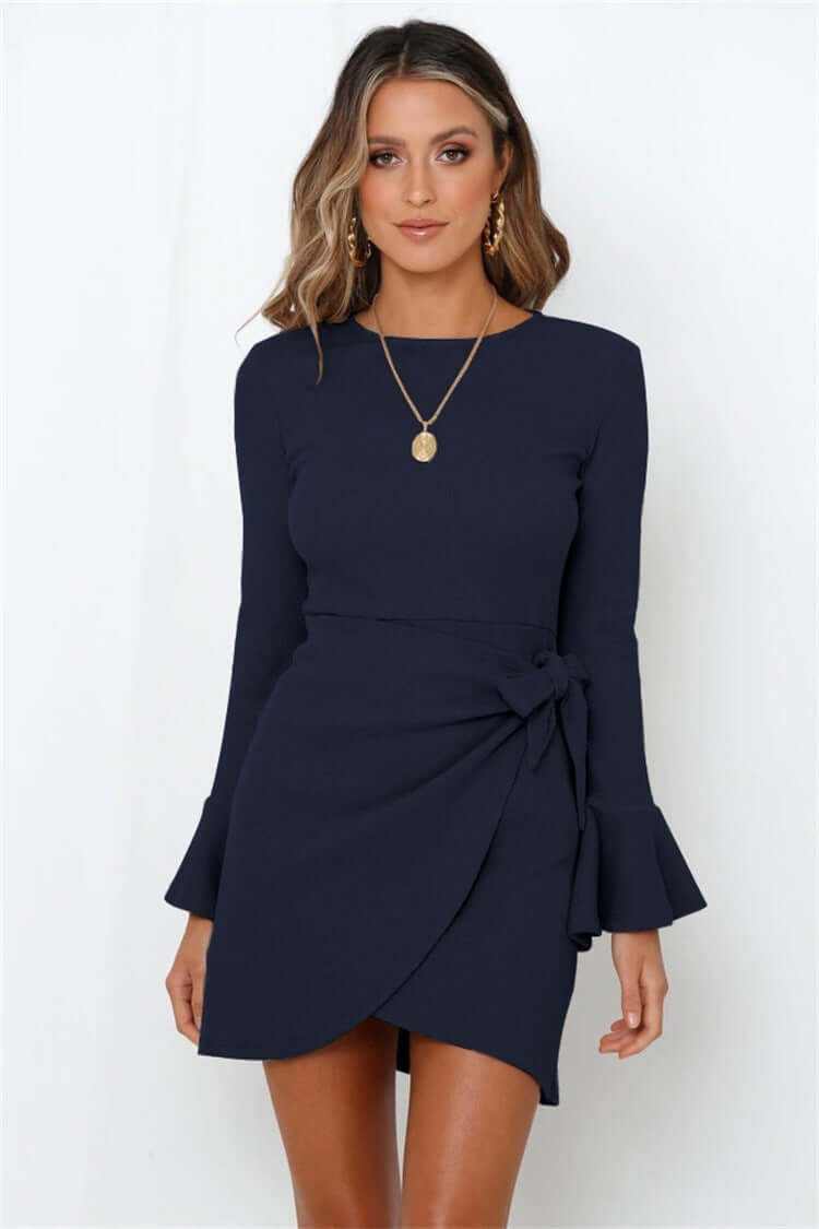 woman wearing navy blue women's ruffle long sleeve dress with flare sleeves and high waist bow detail