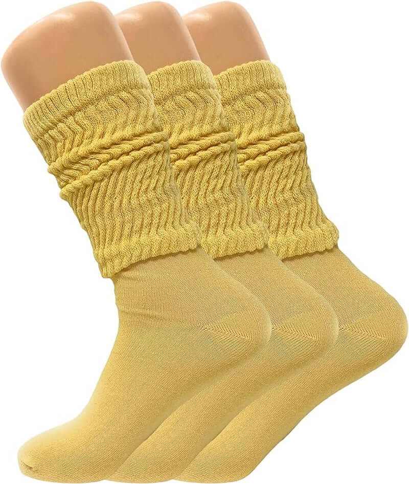 Three pairs of women's slouch knee high socks in a soft yellow color, showcasing their relaxed design.