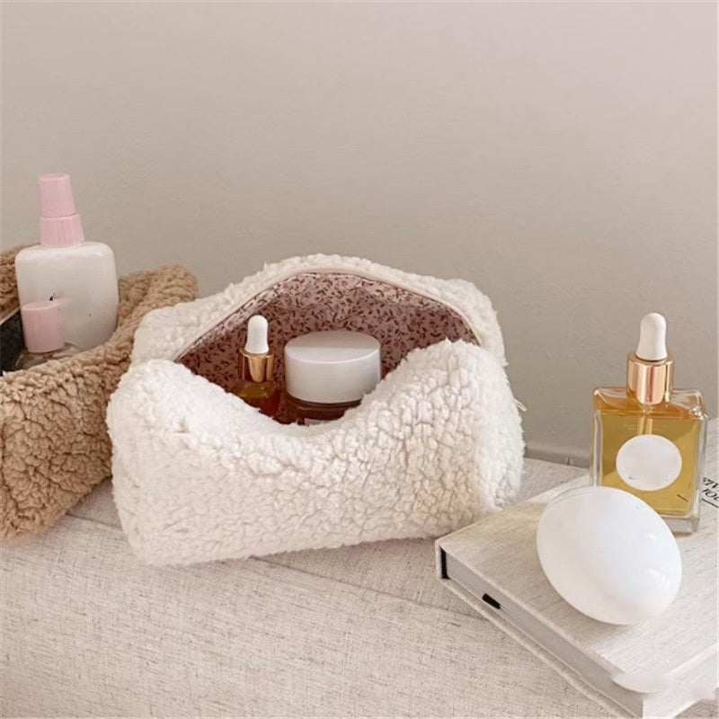 White zipper closure plush cosmetics bag with floral inner lining and skincare bottles inside