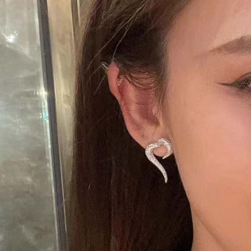 Female wearing shiny heart-shaped zircon stud earrings in white gold copper alloy